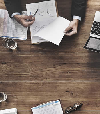 table with business papers and laptop